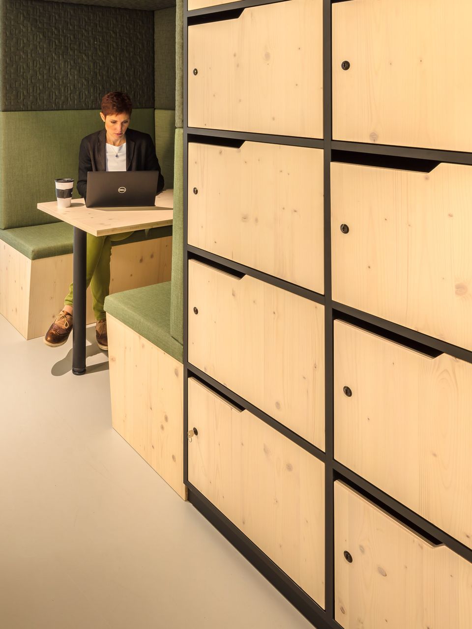 Innenaufnahme einer kleinen Arbeitsnische mit Holzverkleidung, gepolsterter Sitzbank und Tisch für konzentrierte Einzelarbeit.