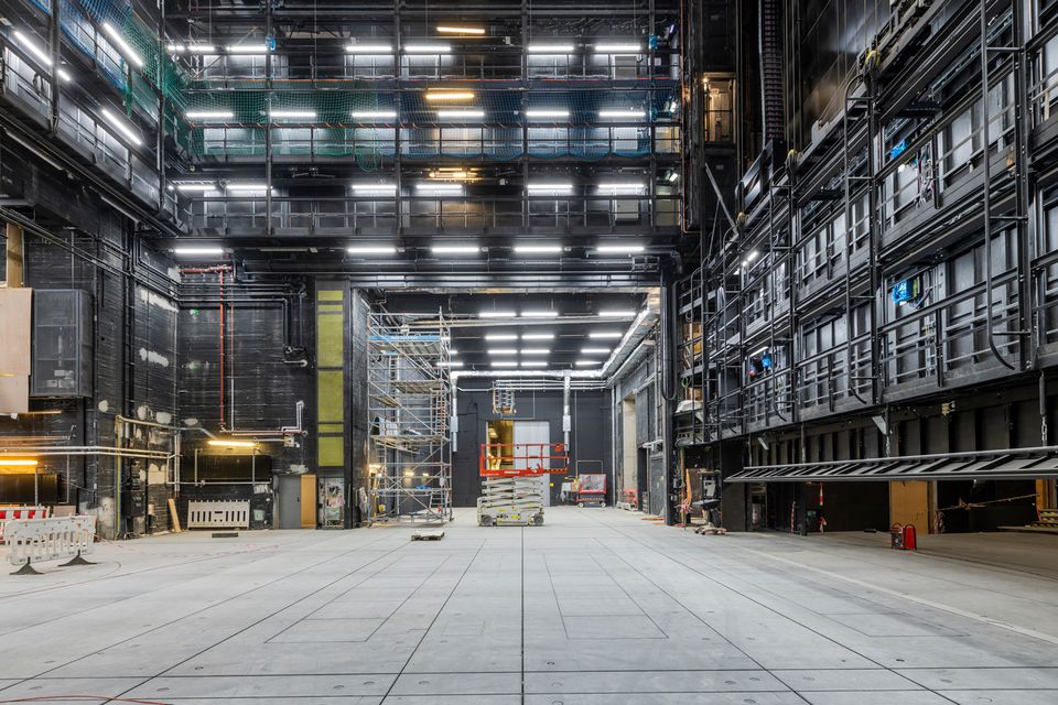 Großer technischer Bühnenbereich mit offenen Metallstrukturen und Arbeitszonen.
