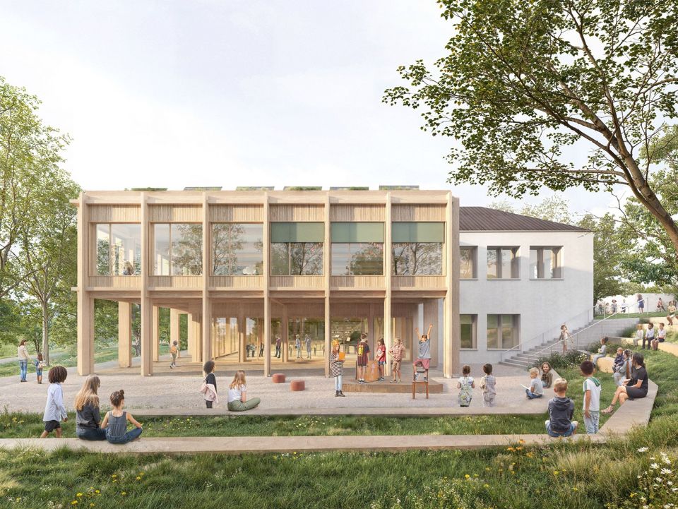 Außenvisualisierung eines Schulgebäudes mit Holzfassade, überdachtem Eingangsbereich, weitläufigen Spielflächen und umgebenden Grünräumen.