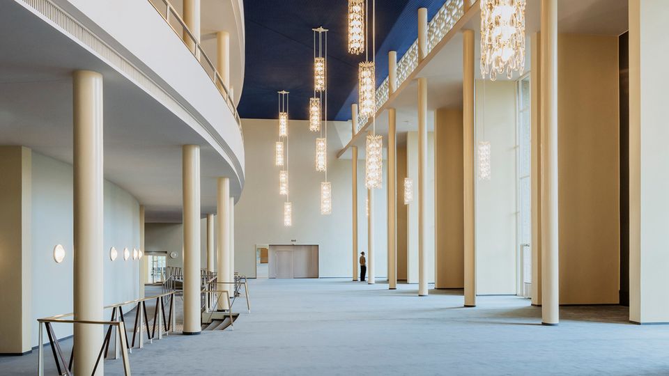 Moderner Vorplatz mit großer Glasfassade und farbigen Sitzmöbeln bei Tageslicht
