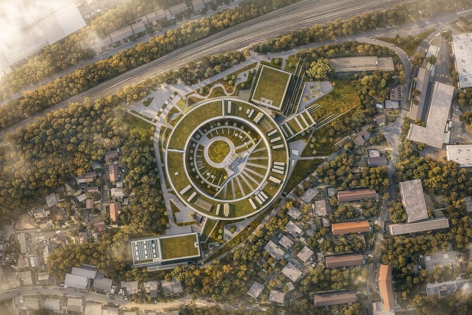 Draufsicht auf ein ringförmiges Gebäudensemble mit begrünten Dachflächen, radialer Struktur und umliegender Grünlandschaft.