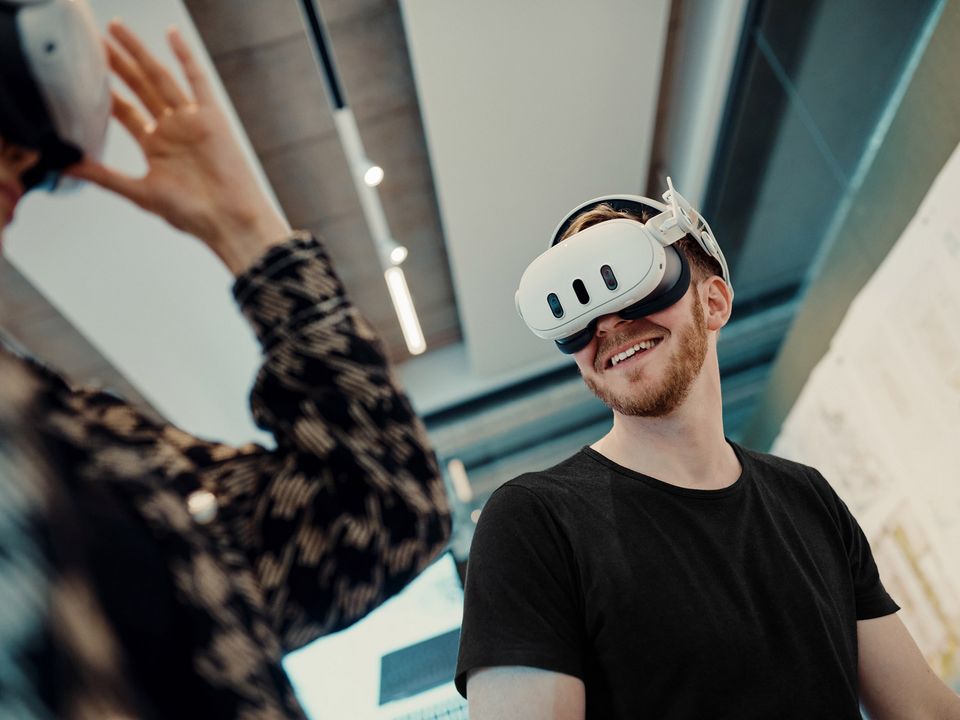 Person nutzt ein Virtual-Reality-Headset in einem modernen Arbeitsumfeld.