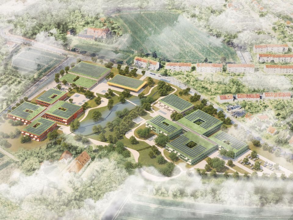 Luftaufnahme eines modular angeordneten Campusensembles mit begrünten Dachflächen, zentralen Freiräumen und umliegender Wohnbebauung im städtischen Kontext.