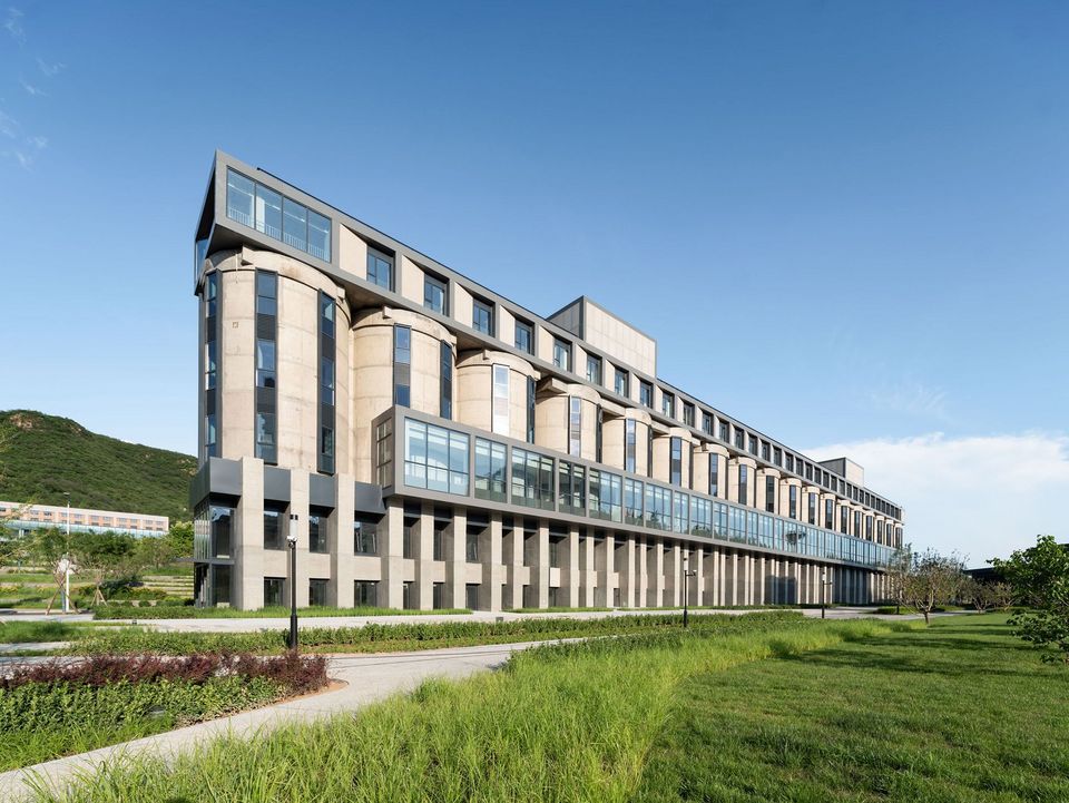 Schrägansicht eines industriellen Silokomplexes mit durchgehenden Rundkammern, offenen Tragstrukturen und umliegendem Baustellenumfeld.