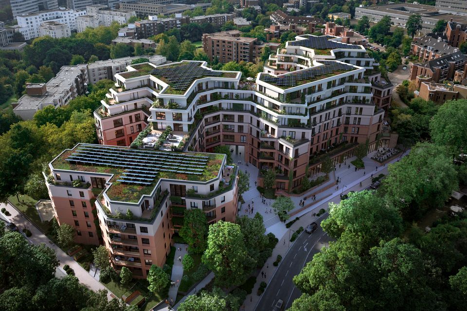 Luftvisualisierung eines terrassierten Wohnensembles mit begrünten Dachflächen, gestaffelten Baukörpern und innenliegendem Quartiershof in einem dicht bewaldeten Stadtumfeld.