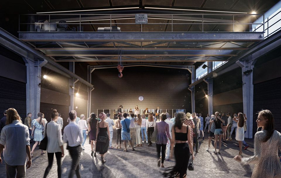 Innenaufnahme einer Konzert- und Eventhalle mit industriellem Tragwerk, Oberbühne, seitlicher Beleuchtung und Publikum vor der Bühne.