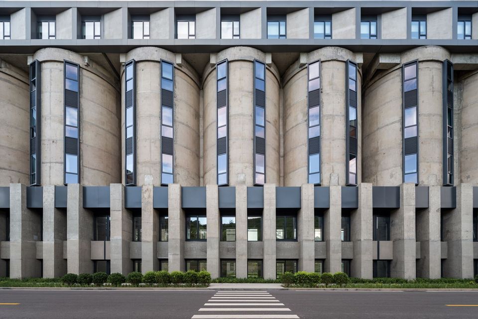 Frontalaufnahme eines Silogebäudes mit vertikal gerasterten Rundkammern, durchgehenden Fensterfeldern und klar gegliedertem Sockelbereich.