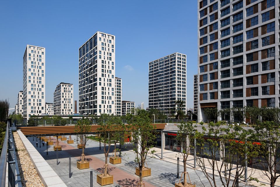 Innenhof mit begrünten Flächen und umliegenden Wohnhochhäusern im Expo Village Shanghai.