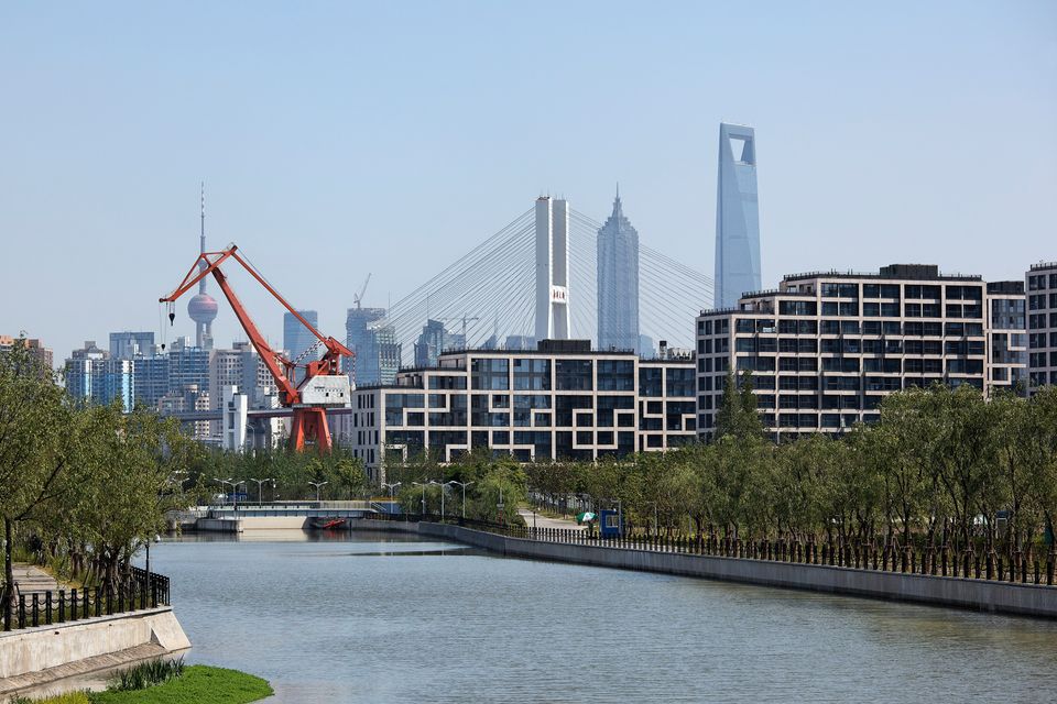 Blick über Fluss auf Wohnbauten und Skyline von Shanghai beim Expo Village.
