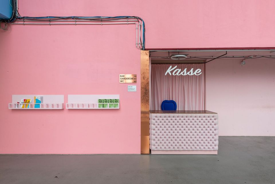 Kleiner Kassenbereich mit rosa Wand und schlichtem Verkaufstresen