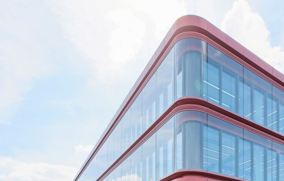 Detailaufnahme einer geschwungenen Glasfassade mit mehrgeschossigen Fensterbändern und dynamischem Fassadenverlauf unter hellem Himmel.