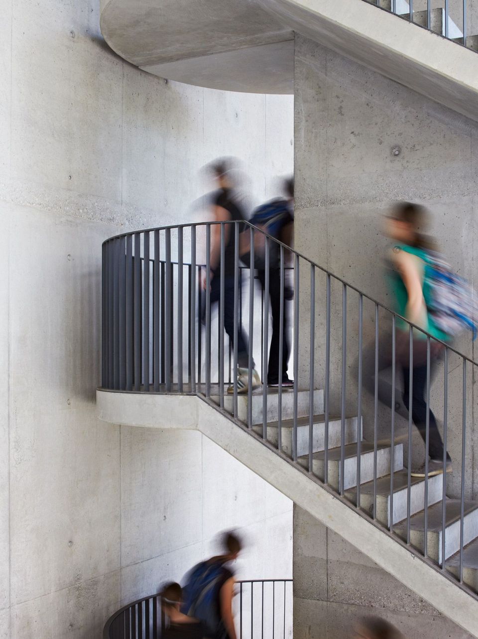 Innenansicht einer Wendeltreppe aus Sichtbeton und Metallgeländer, funktionales Design im Parkhaus