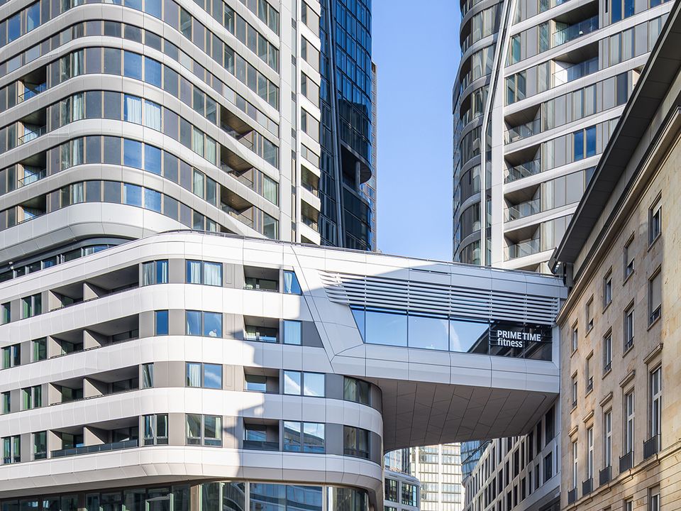 Exterior view of a high‑rise building with a distinctive façade, vertical design lines and surrounding urban development.