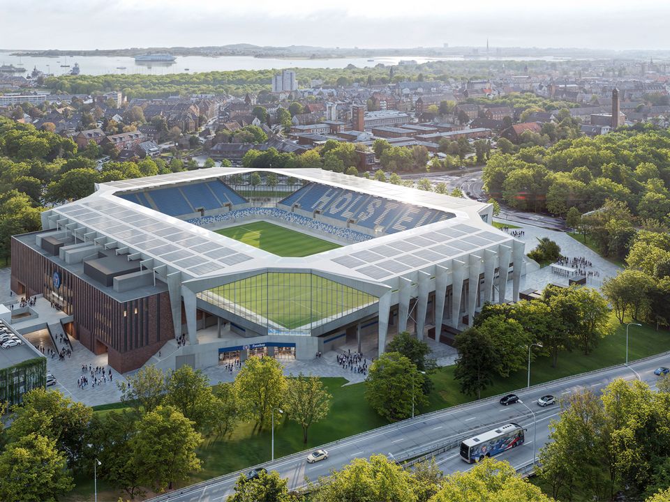 Luftaufnahme eines modernen Fußballstadions mit umlaufender Tribünenstruktur, großflächigen Dachmodulen und Lage im urbanen Umfeld nahe einer Grünanlage.