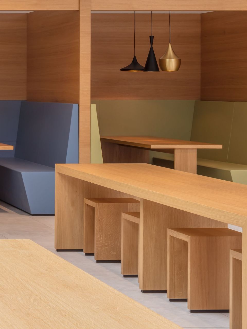 Detailaufnahme der Sitzkojen und Tische im Betriebsrestaurant mit klarer Holzstruktur und zurückhaltender Zonierung.