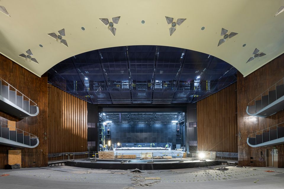 Großer Saal mit hölzernen Wandverkleidungen und moderner Bühnentechnik